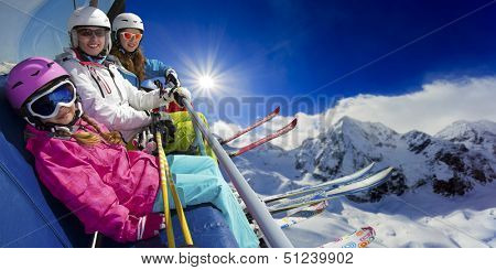 Ski lift, skiing, ski resort - happy skiers on ski lift