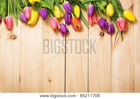 Spring Flowers bunch at wood floor texture. Beautiful Tulips bouquet gift. Easter or Mother's Day  background. Springtime or summertime. Invitation card design with space for your text