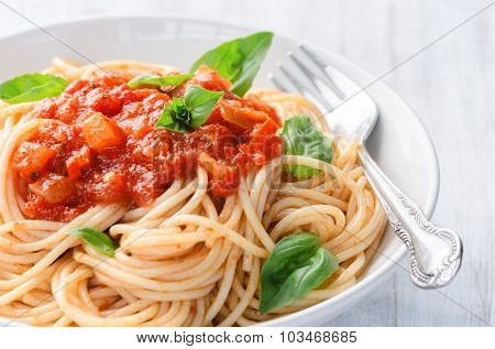 Spaghetti pasta with tomato sauce and basil herb garnish, simple ready to eat meal