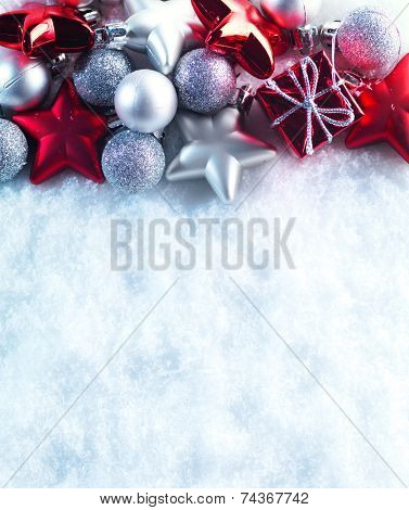 Winter and Christmas background. Beautiful sparkling silver and red Christmas decoration on a white snow background. Ornamental Christmas concept. Close up with copy space.