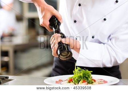 Chef im Hotel oder Restaurant Küche kochen, nur Hände um zu sehen, er ist Speisen würzen