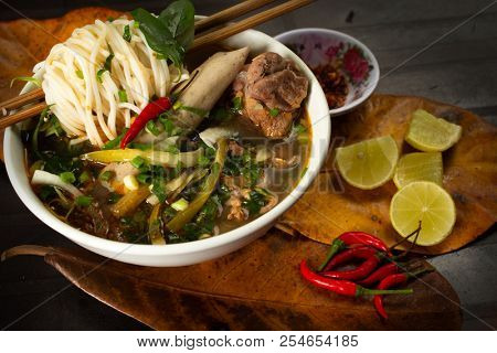 
 Save
Download Preview
Traditional vietnamese noodle soup pho in bowl garnished with basil mint lime on concrete background. Vietnamese beef soup pho bo. Close-up.  Vietnamese dinner. Pho bo meal