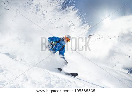 Skier skiing downhill in high mountains