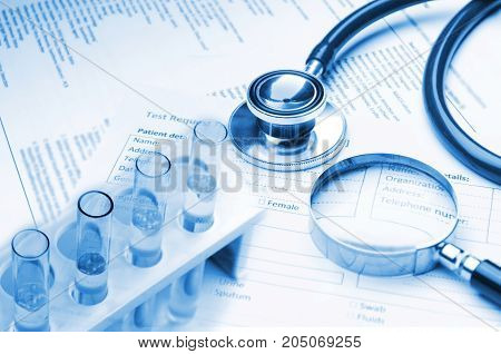 double exposure of stethoscope laboratory test tube magnifying glass and medical information form on desk medical research diagnosis medical report record and history patient concept blue tone