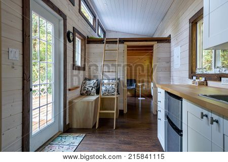 Interior design of a dining room and kitchen in a tiny rustic log cabin.