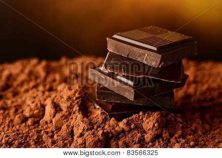 Heap Of Blocks Of Chocolate On Cocoa Powder