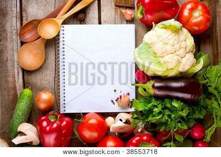 Vegetables and Spices on a Wooden Background and Paper for Notes.Open Notebook and Fresh Vegetables Background.Diet.Dieting.Space For Your Text