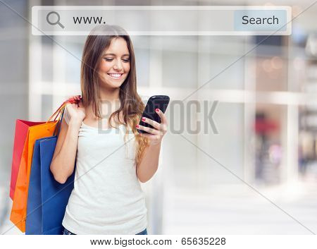 Young woman holding shopping bags and a mobile phone