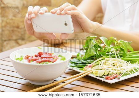 Young Woman Taking A Picture The Pho Bo On Smartphone In Vietnam