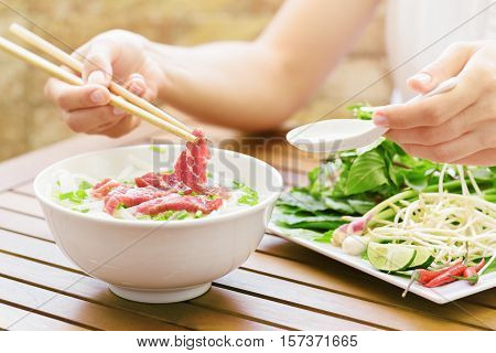 Young Woman Eating The Pho Bo In Street Cafe Of Vietnam