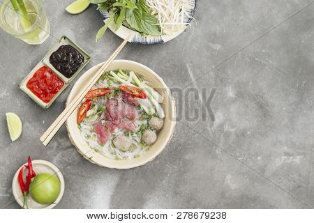 Traditional Vietnamese Soup Pho Bo With Herbs, Meat, Rice Noodles, Broth. Pho Bo In Bowl With Chopst