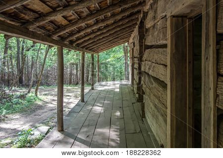 Log Cabin Front Porch. Wooden front porch of a pioneer era log cabin home. This a historical home open to the public in the Smoky Mountains National Park. It is not a private residence.