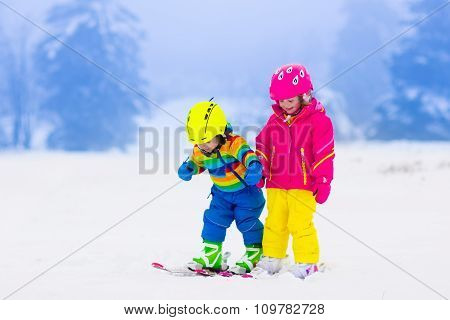 Two Children Skiing In Snowy Mountains