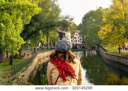 Woman Relaxing On Bridge In Strasbourg. Vacations Lifestyle. Woman Looking To River .vacation Lifest