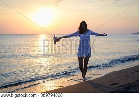 Beautiful Woman Smiling On Beach. Happy People Lifestyle. Woman Smiling In Sunset With Arms Outstret